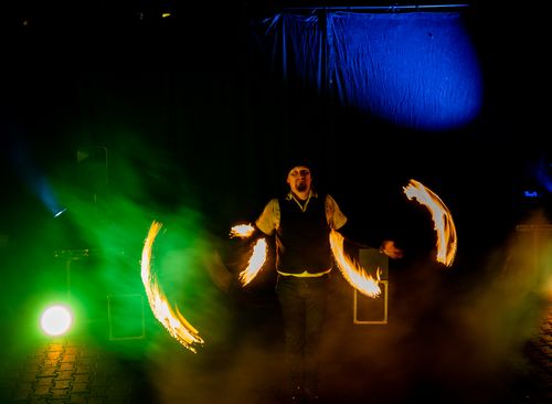 Feuerkünstler jongliert brennende Stäbe