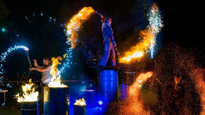 Feuershow mit brennden Fässern und Funken Effekten